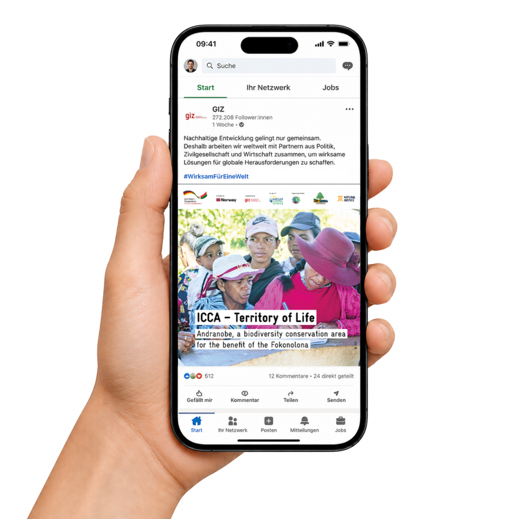 Hand h&auml;lt ein Smartphone mit einem Social-Media-Beitrag &uuml;ber nachhaltige Entwicklung und gemeinschaftlichen Naturschutz in einer lokalen Gemeinschaft.